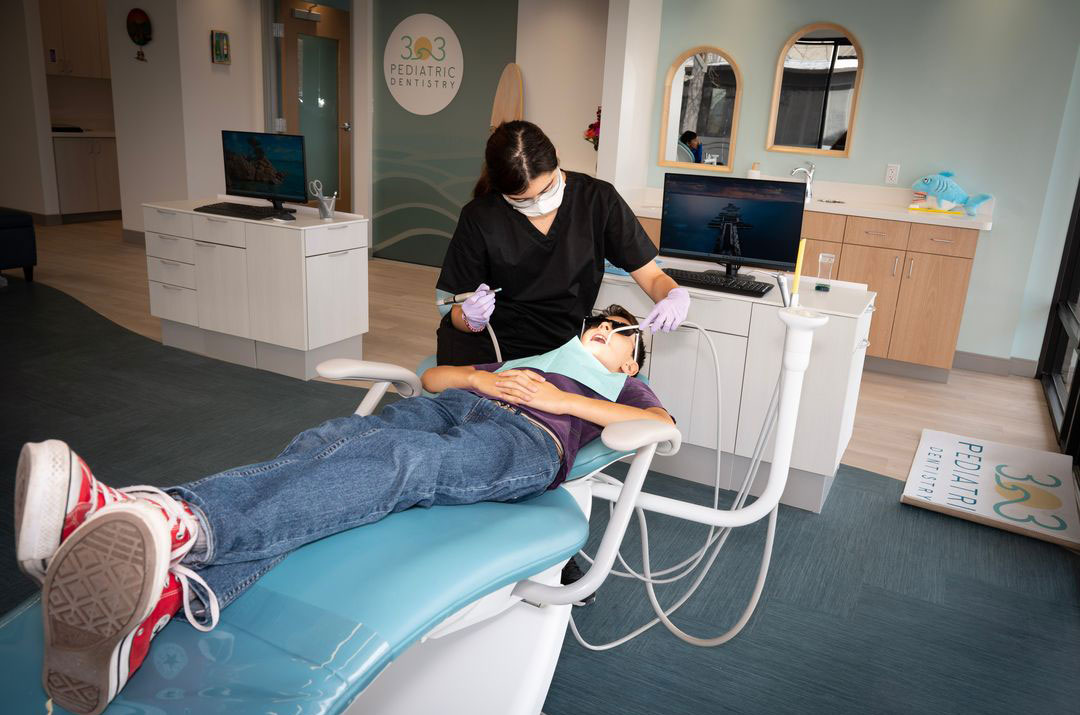 A dental professional is assisting a patient during a dental appointment.